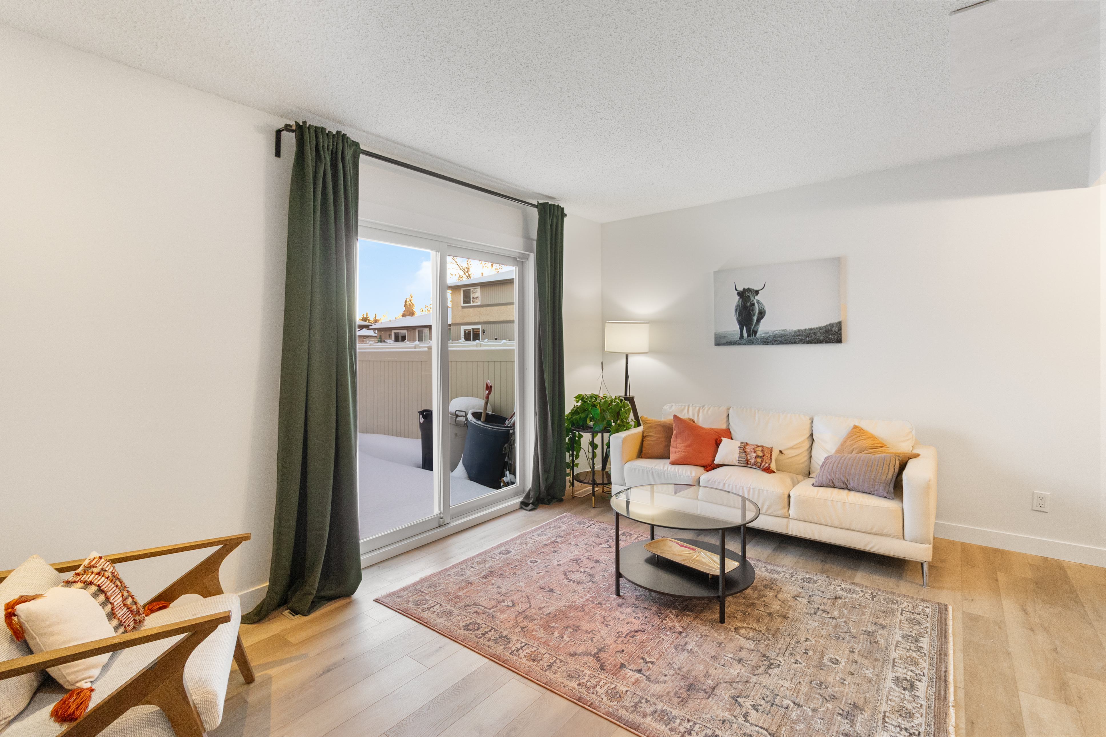 Fort Sask living room — slider, warm staging